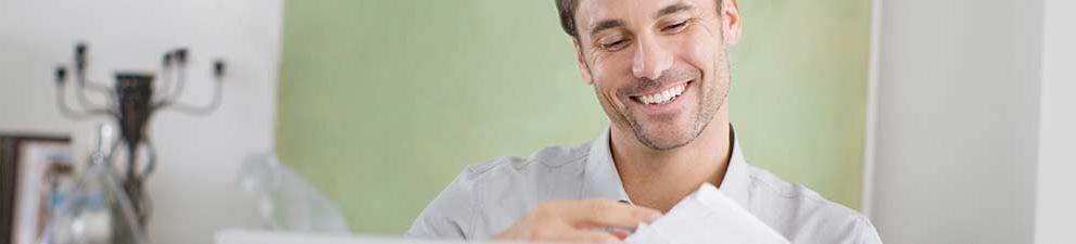 Small business owner opening customer reply mail envelopes.