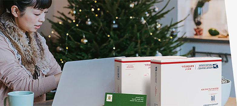 A woman preparing to ship holiday gifts with a Priority Mail Express box and a Priority Mail box.