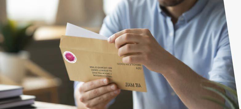 Person preparing to send a letter using First-Class Mail International service.